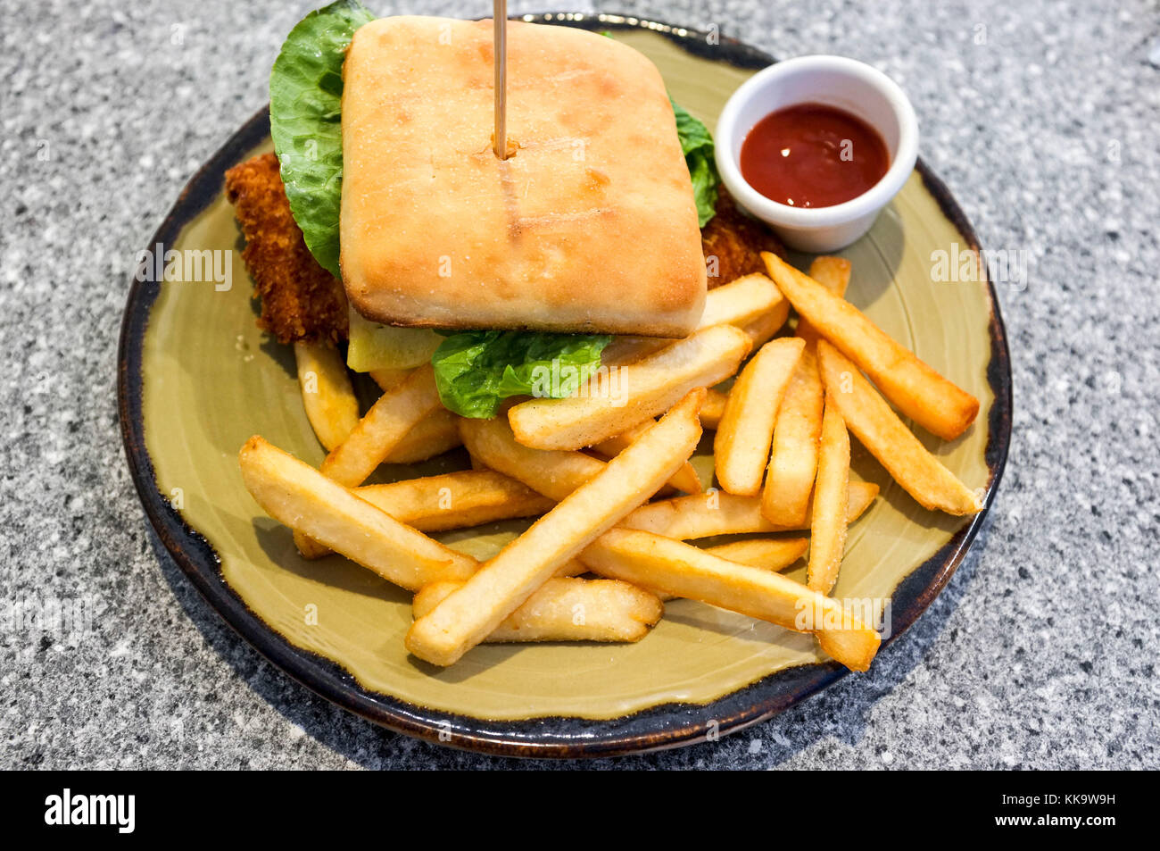 Ein Huhn schnitzel Burger mit Pommes Frites und Tomatensauce. Stockfoto