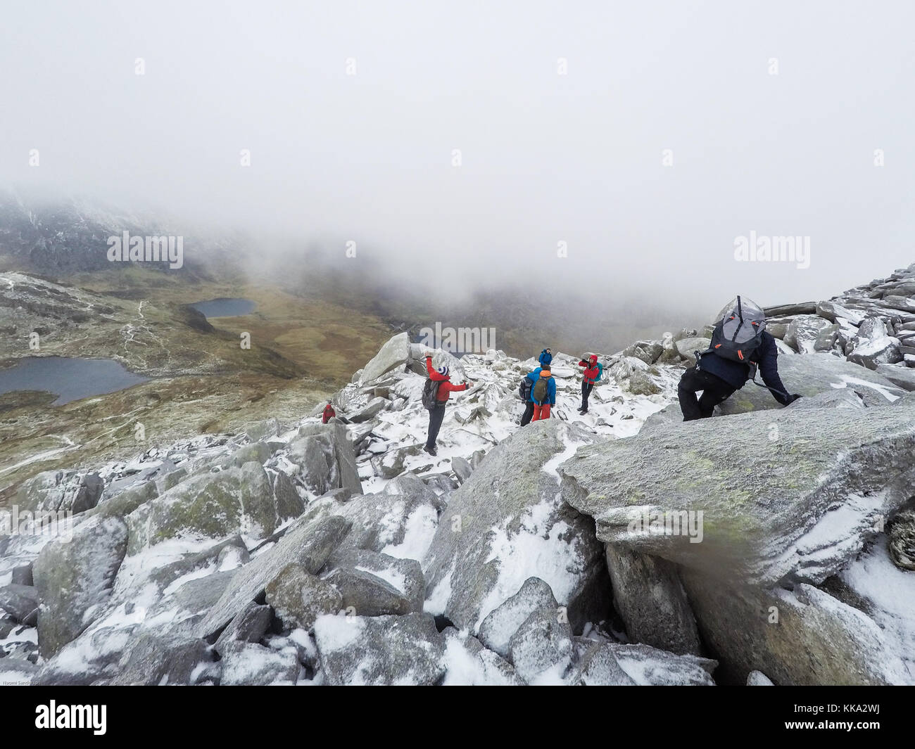 Gruppe Walking im Winter Landschaft, Tryfan, Ogwen Valley, Snowdonia, Wales, Großbritannien Stockfoto