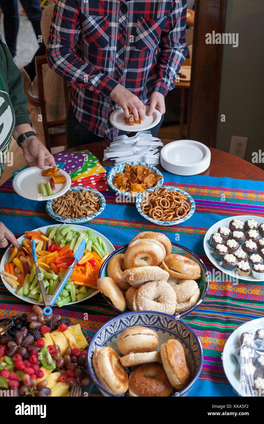 Gäste helfen, sich selbst zu Party Food an einem Haus sammeln. Stockfoto