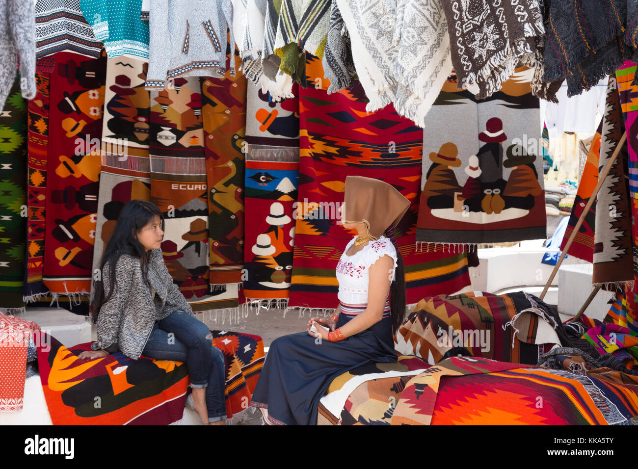 Zwei lokale Ecuadorianischen junge Frauen sprechen in einem Marktstand, Otavalo Markt, Otavalo, Ecuador Lateinamerika Stockfoto