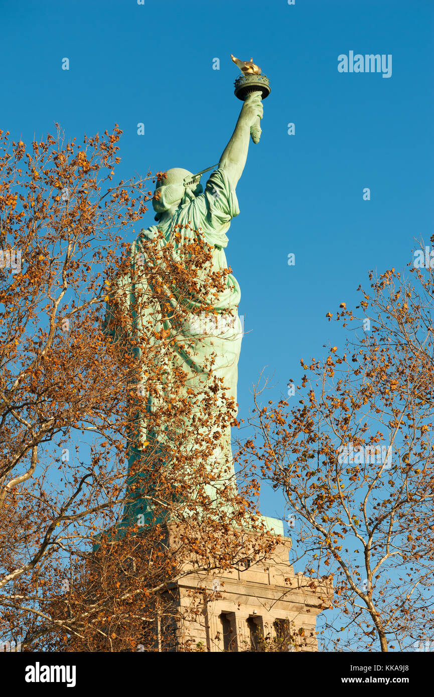 Freiheitsstatue Ansicht von hinten gegen den blauen Himmel hinter Bäumen in aut Stockfoto