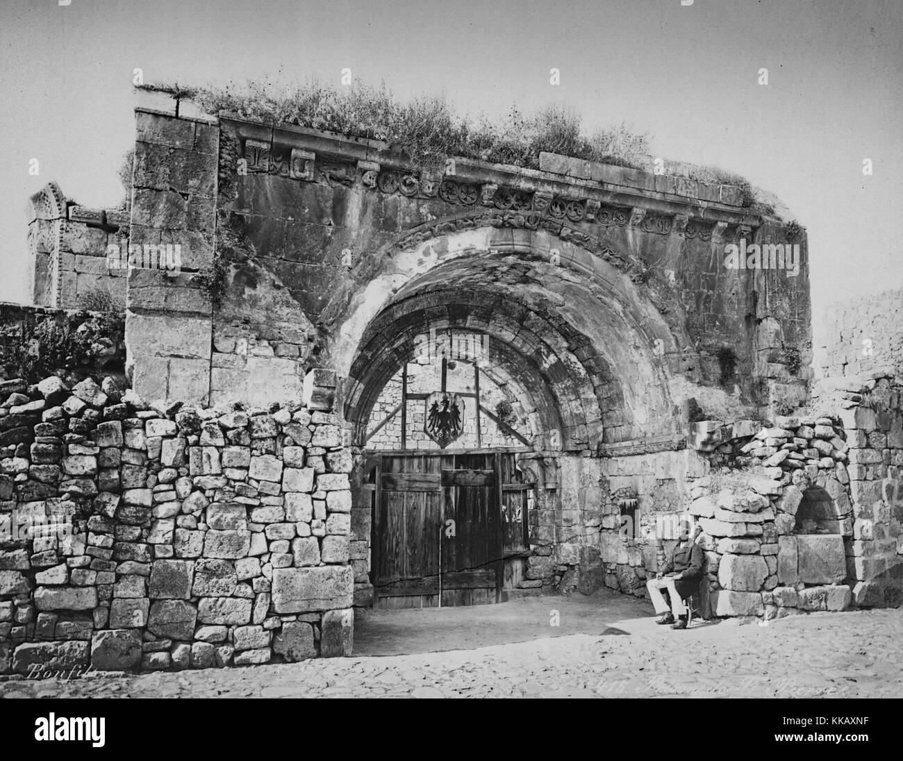 Ein Mann sitzt vor dem Eingang in ein Gebäude, das als Gefängnis de St. Pierre oder St. Peter's Gefängnis, von dem Fotografen, 1900 festgestellt wurde. Von der New York Public Library. Stockfoto