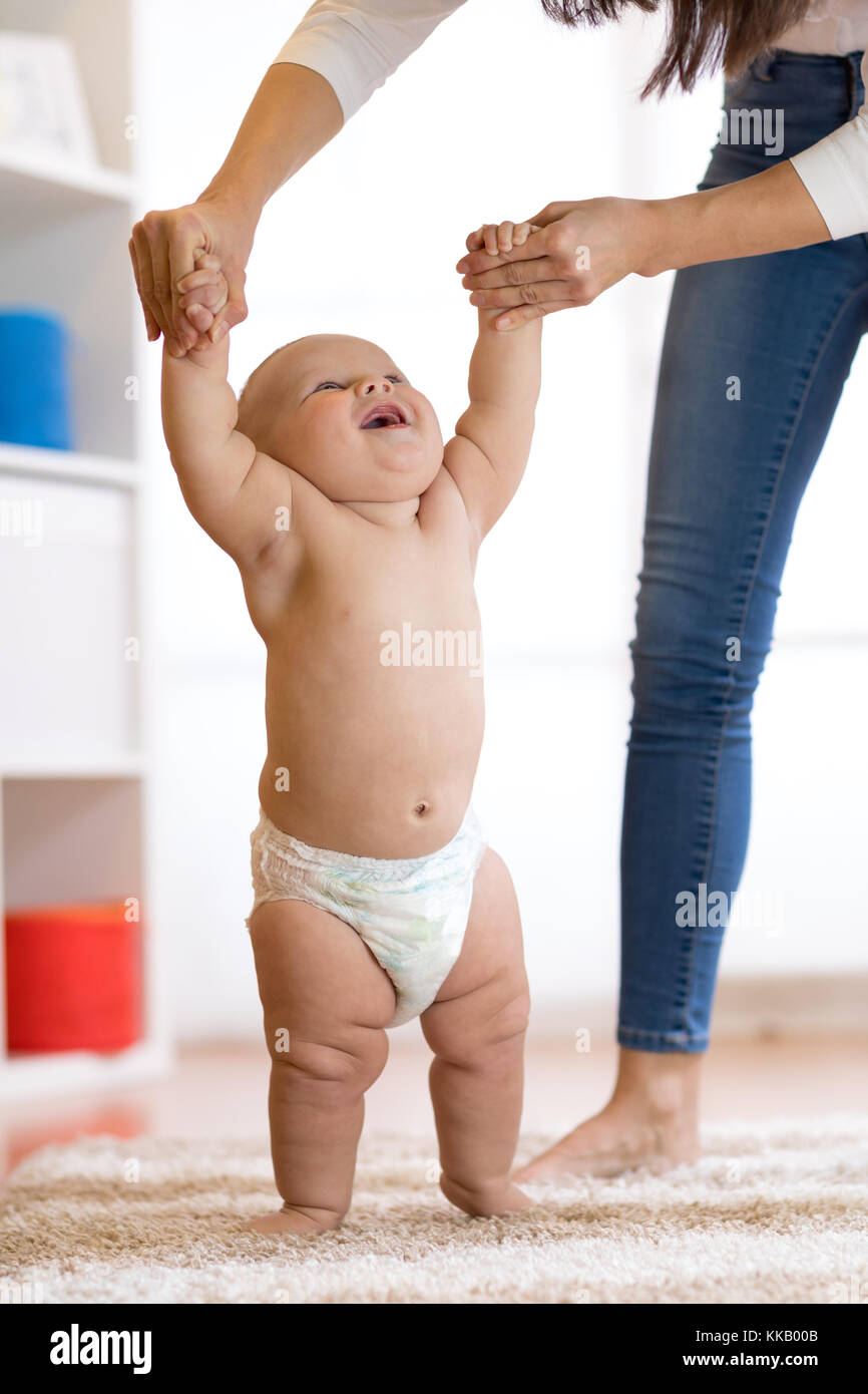 Baby, die ersten Schritte mit Hilfe der Mutter Stockfoto