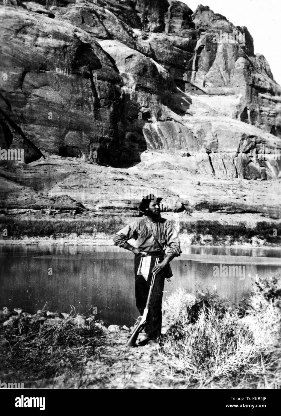 Ein Foto von John-F.-Verwalter mit seinem Gewehr in Glen Canyon entlang des Colorado River in der Powell Umfrage, Utah posieren. Bild mit freundlicher Genehmigung durch USGS. 1872. Stockfoto