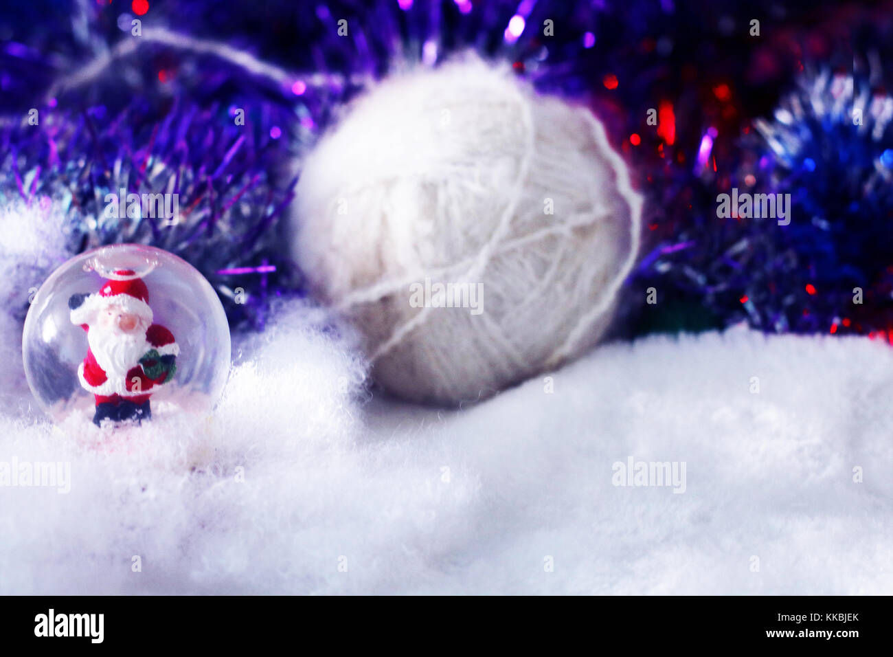 Weihnachten und neues Jahr Hintergrund mit Santa Claus in Glaskugel, weiß Garn auf weichen Defokussierten snowy Hintergrund mit Lametta. Stockfoto