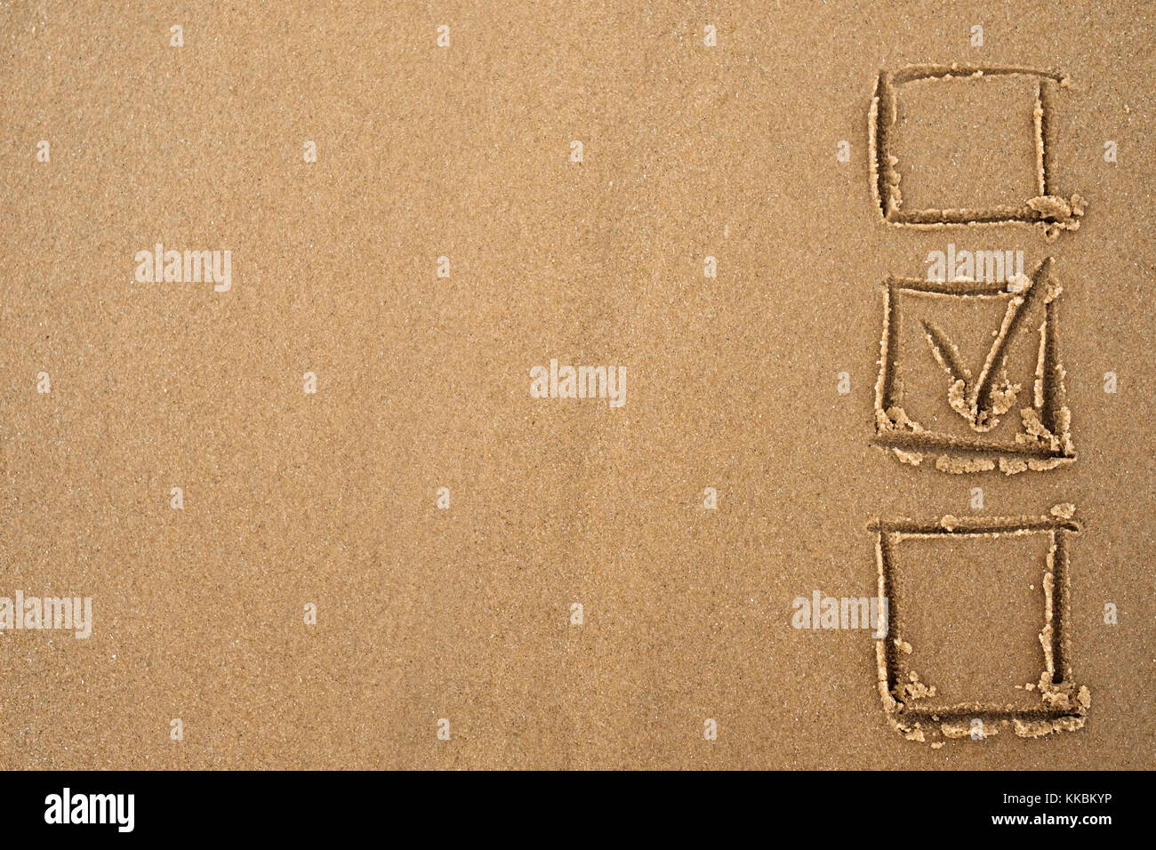Das Konzept der Wahl. einen Haken im Fragebogen auf den Sand gezogen. Stockfoto