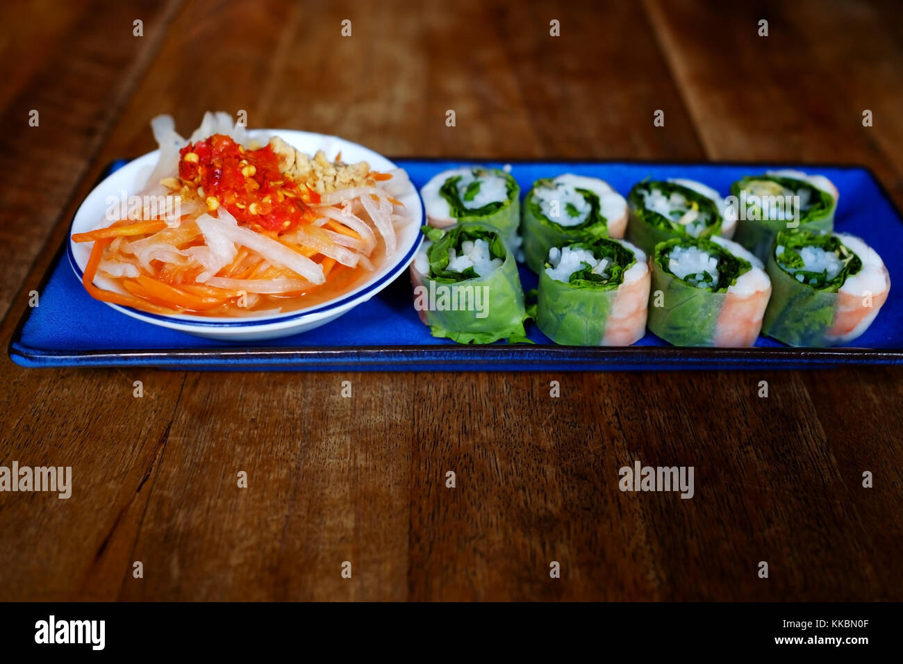 Eine neue Rolle mit Gemüse und Reis mit Soße auf blauen Platte Stockfoto