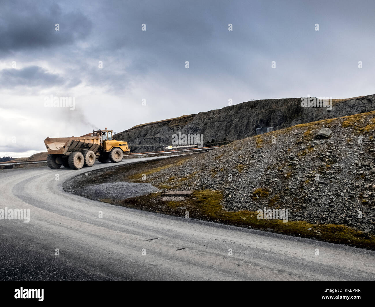 Große gelbe Moxy Lastwagen durch die Bergigen Valley Road fahren. Stockfoto
