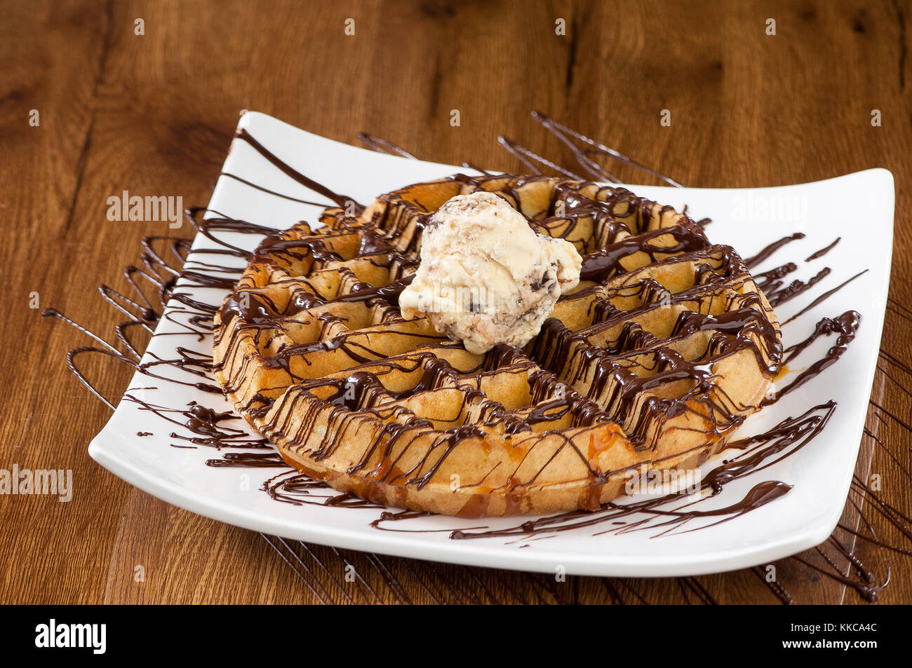 Wafer Kuchen in einem quadratischen weißen Teller auf einem hölzernen lackierten Oberfläche mit Reflektion Stockfoto