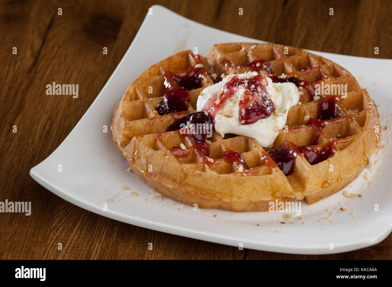 Wafer Kuchen in einem quadratischen weißen Teller auf einem hölzernen lackierten Oberfläche mit Reflektion Stockfoto