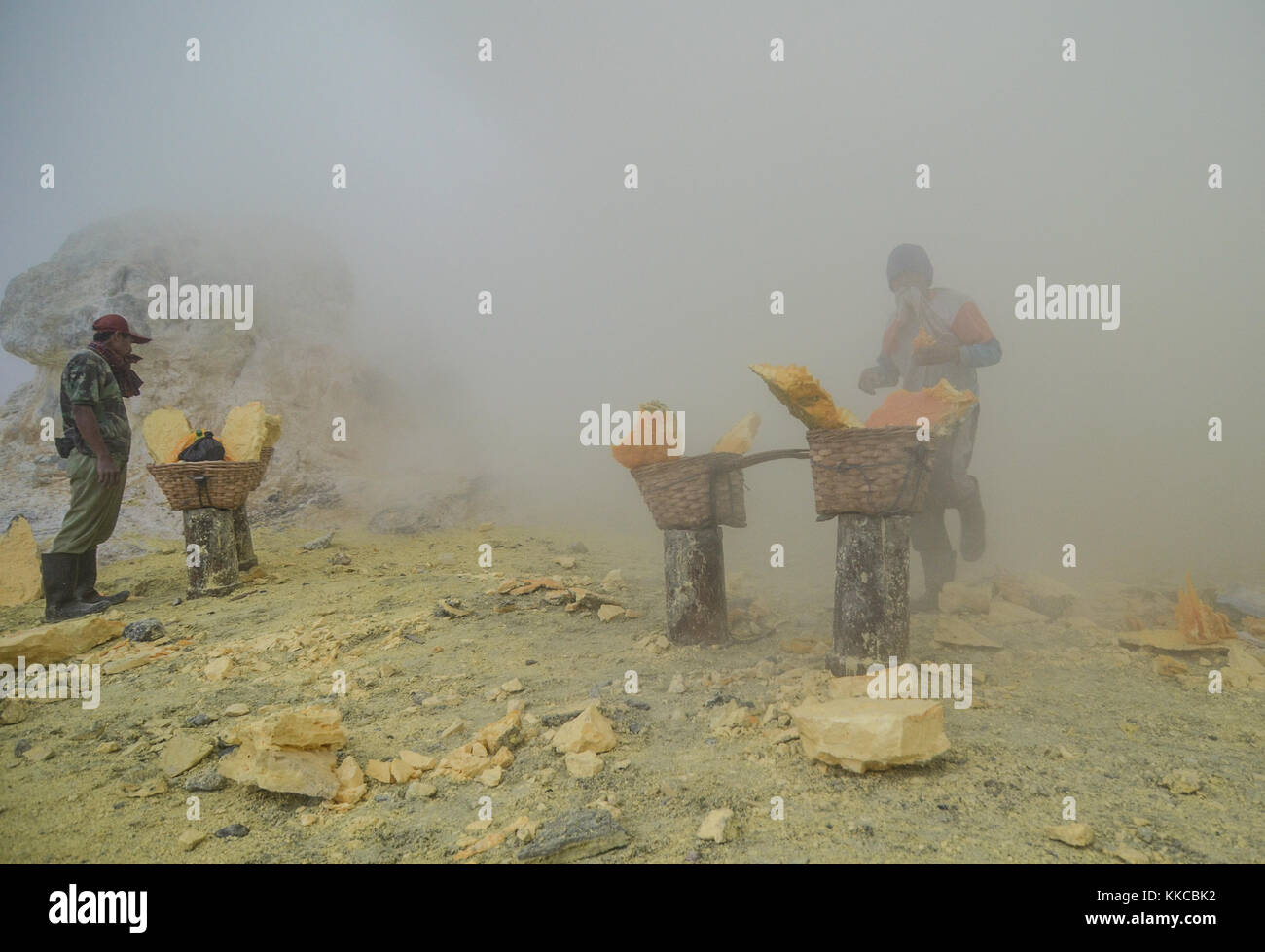 Schwefelminer von Kawah Ijen, vor dem erstickenden Rauch in Sicherheit Stockfoto