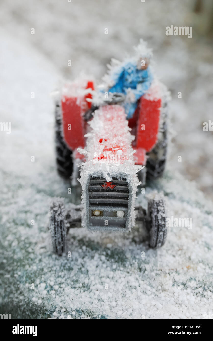 Spielzeug Traktor mit Fahrer in Eis cystals, Wales, UK abgedeckt. Stockfoto