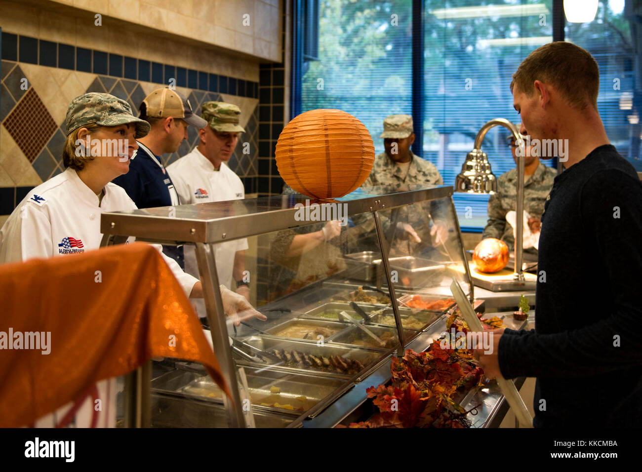 Kol. Jennifer Kurz, 23d Wing Commander, Links, serviert Speisen zu Airman 1st Class Tristan Batten, 23d Bauingenieur Squadron Wasser und Brennstoffe system Wartungstechniker, am Thanksgiving Tag in der Georgia Kiefern Speisesaal, November 23, 2017, bei Moody Air Force Base, Ga. Das Erntedankfest Mahlzeit war eine Gelegenheit für Flieger, Rentner, Hinterbliebenen und Führung ein traditionelles Erntedankfest Mahlzeit zu geniessen. (U.S. Air Force Foto von Airman 1st Class Erick Requadt) Stockfoto