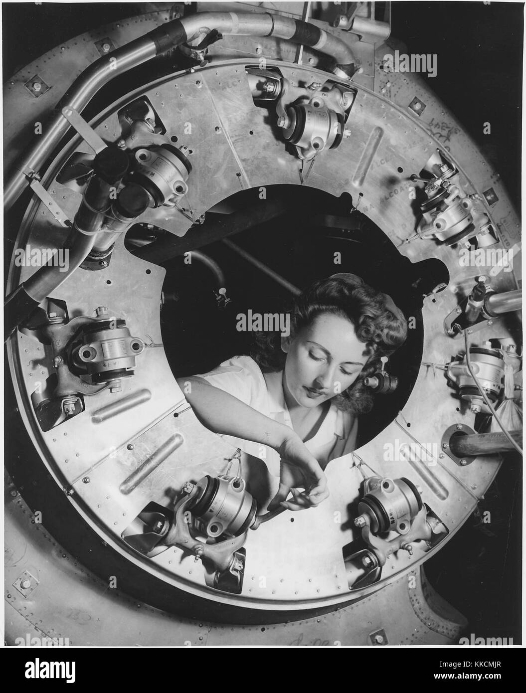 Teil der Verkleidung für eine der Motoren für ein B-25 Bomber ist in der Abteilung des nordamerikanischen Inglewood, Kalifornien Anlage durch eine weibliche Arbeiter, der während des Zweiten Weltkrieges 2. Mit freundlicher Genehmigung der nationalen Archive. 1942. Stockfoto