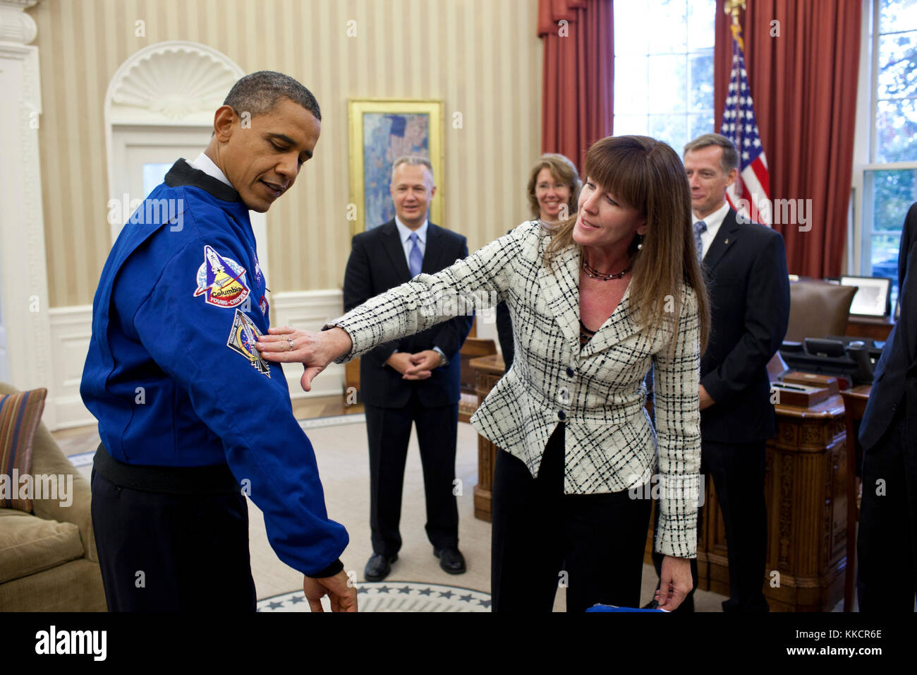 Janet kavandi, Direktor der Flight Crew Operations bei Johnson Space Center, stellt Präsident Obama mit einer Jacke während eines Drop durch mit der Besatzung der Raumfähre Atlantis im Oval Office, sep. 1, 2011. Die Jacke hat Patches aus der Vergangenheit Space Shuttle Missionen. Dargestellt im Hintergrund, von links, sind: Pilot Doug Hurley, Mission Specialist sandy Magnus, Kommandant Chris Ferguson und Mission Specialist Rex Walheim. Stockfoto