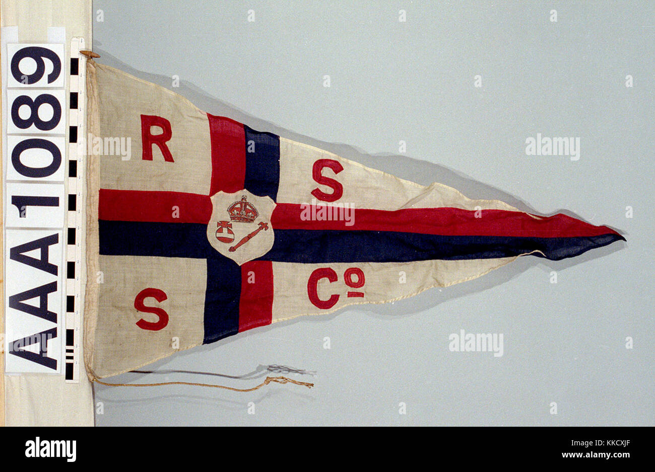 Das Haus Flagge der Royal Sovereign Steamship Co. der Flagge aus Wolle Bunting, Maschine genäht mit einem leinen Hoist. Ein Seil und Holz- toggle ist beigefügt. Ein weißer Wimpel mit einer roten und blauen Kreuzes insgesamt. Ein weißes Wappenschild in der Mitte ist eine rote Krone, Zepter und Reichsapfel. Die roten Buchstaben "R S S Co'. In den nächsten Quartalen. AAA 1089 House flag, Royal Sovereign Steamship Co RMG RP -74-4 Stockfoto