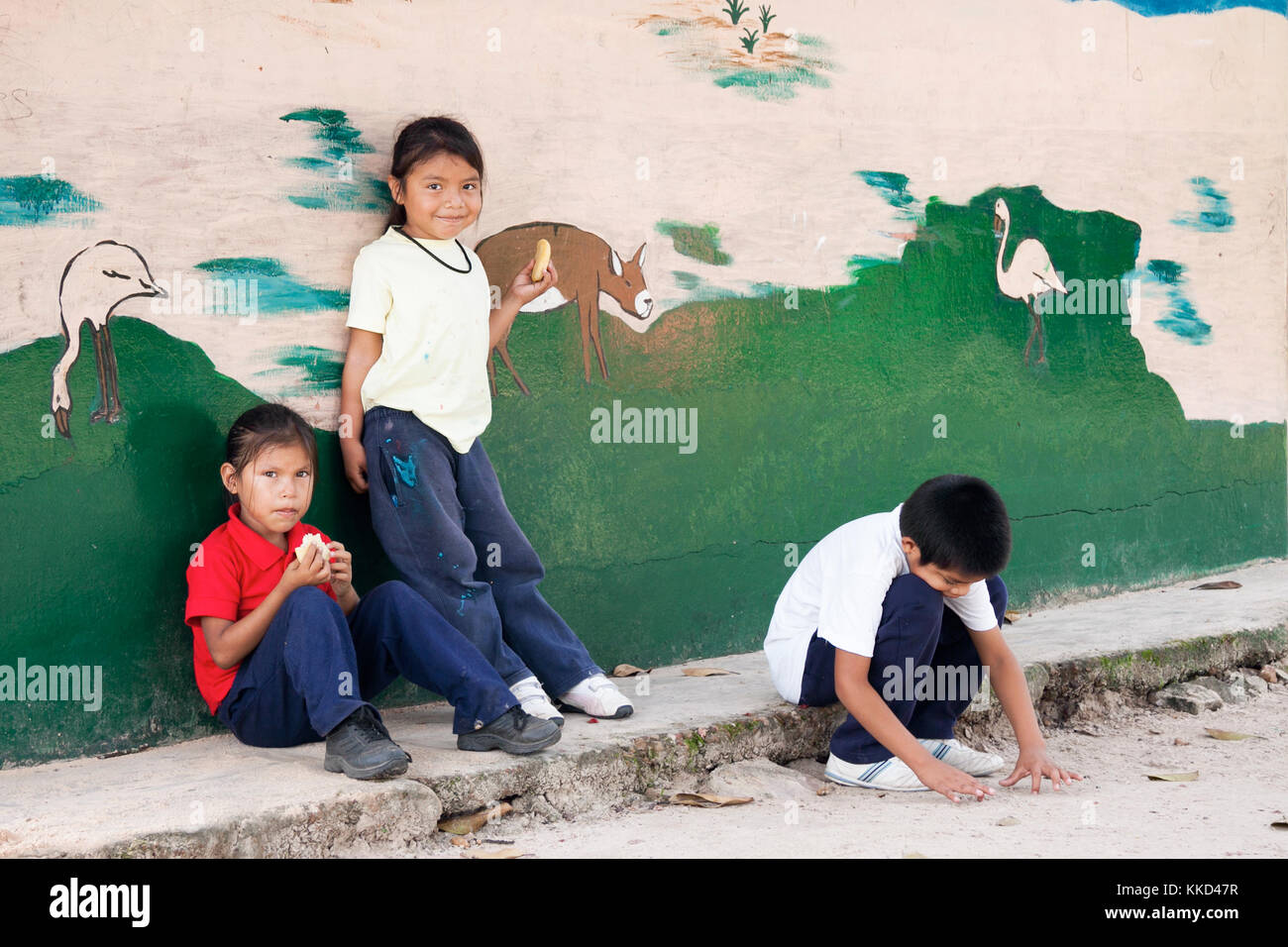Canaima, Venezuela, 11. November 2010: Kinder essen Ihre einfaches Mittagessen außerhalb der Schule neben einer bemalten Wand Stockfoto