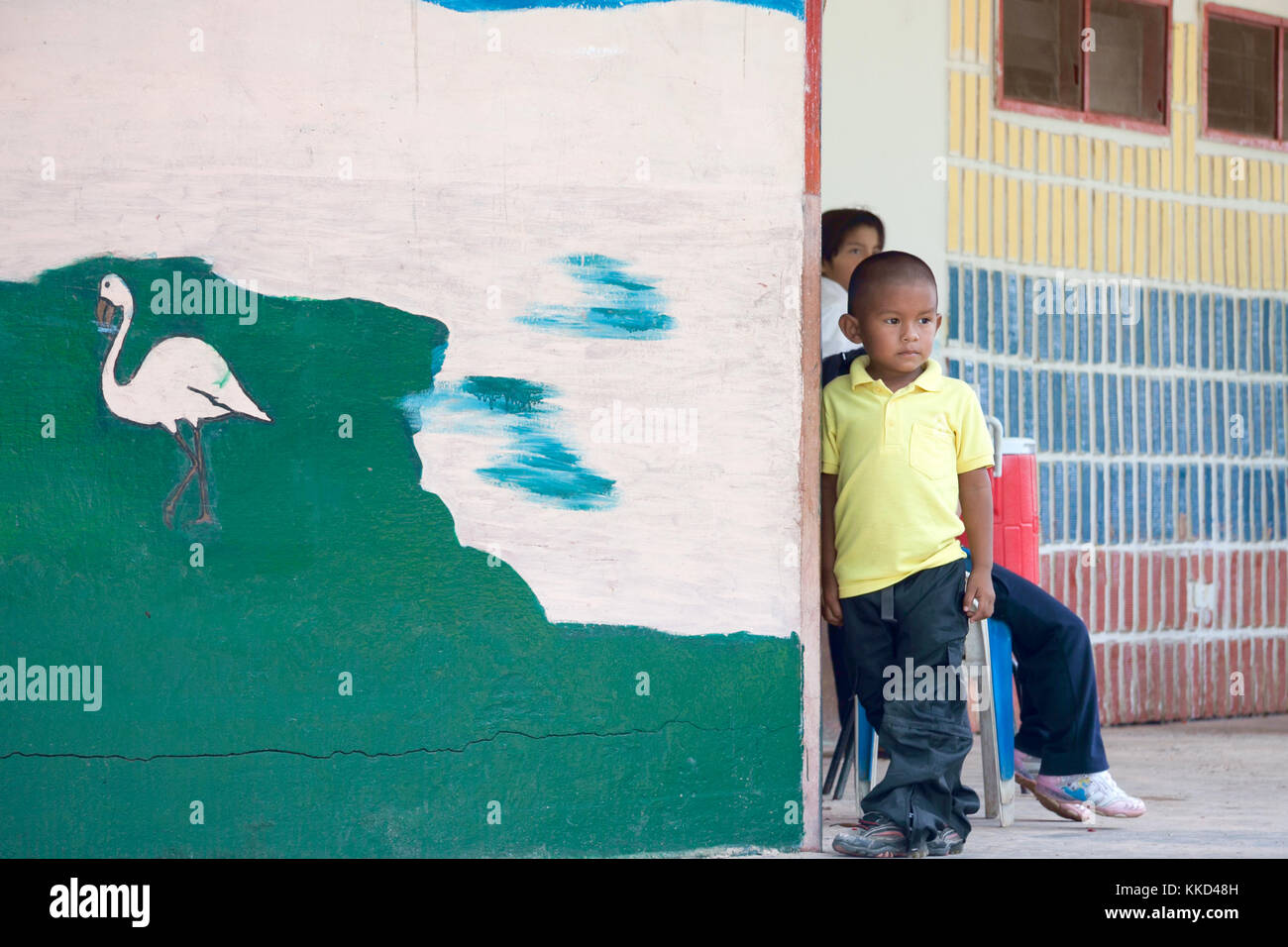Lokale indigene Kinder neben der Schule an der Wand während der kurzen Pause zwischen den Klassen Stockfoto