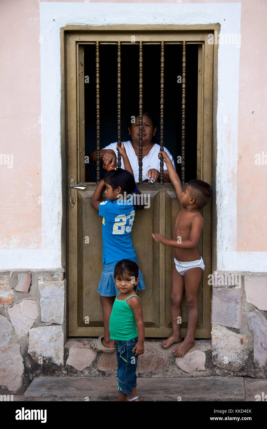 Canaima, Venezuela, 2010-11-11: alte Dame, dass Kinder Geld und Sachen, die durch Bars in Ihrer Tür Stockfoto