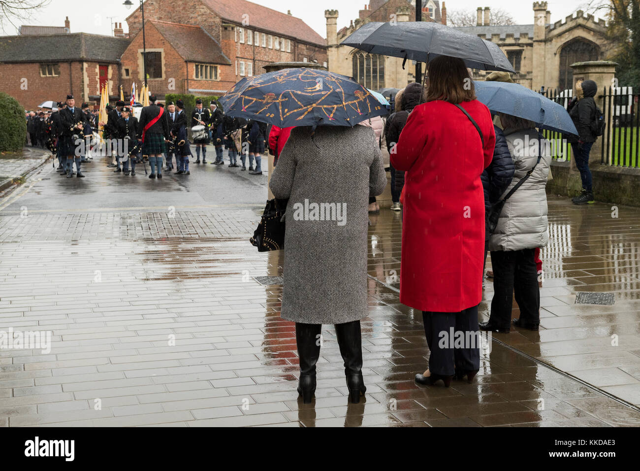 Ansicht der Rückseite des Menschen beobachten Pipe Band & Kriegsveteranen Futter bis vor Beginn der commemorative Parade von York Minster North Yorkshire, England, UK. Stockfoto