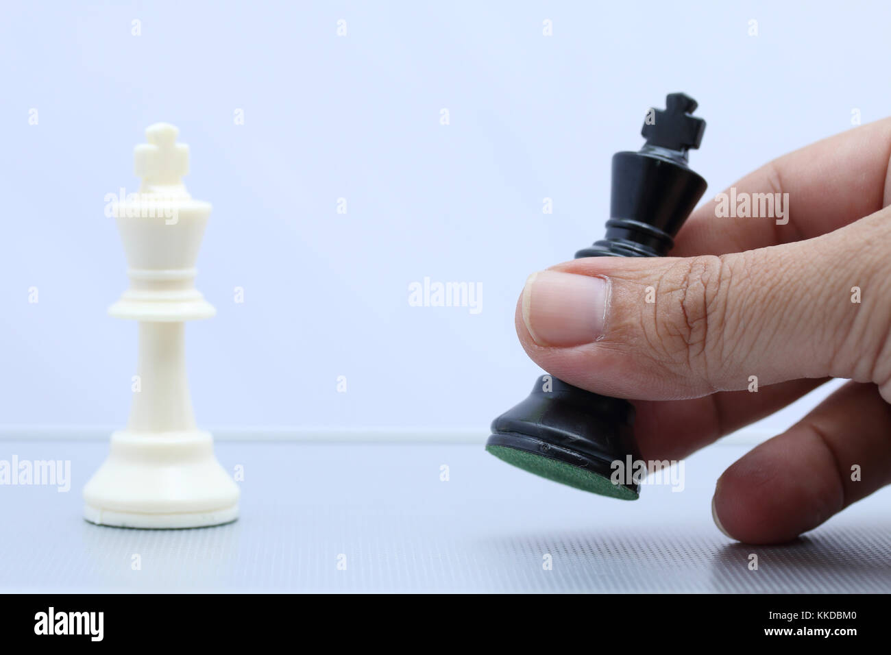 Chess Player macht eine Bewegung der schwarze König Schritt rückwärts. Business Konzept Stockfoto