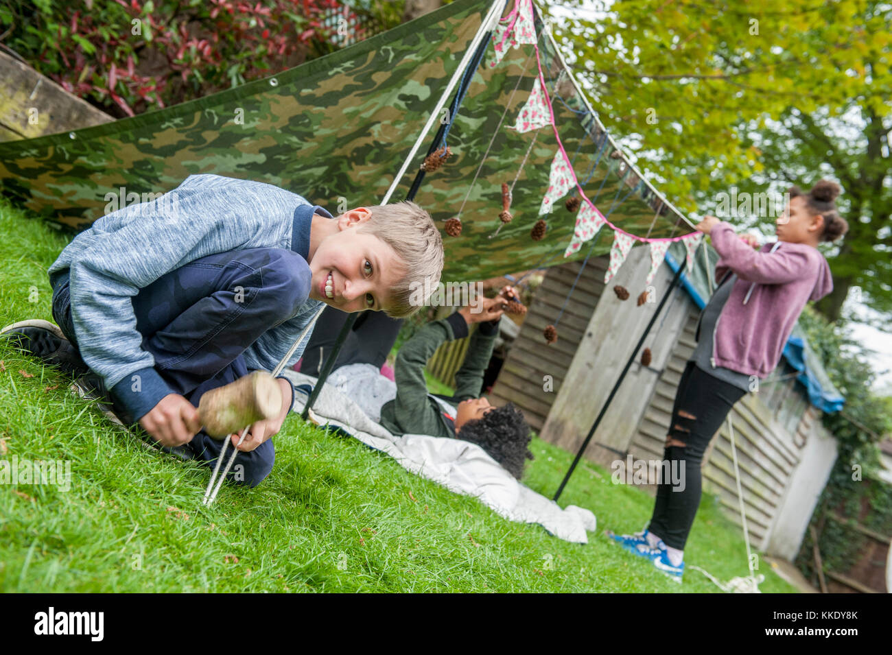 Big wild sleepout Event pix. Bilder der jungen Kinder/Kinder und Eltern, die in Ihrem Garten um von Nachmittag bis in die Nacht - Zeit, genießen Aktivitäten, wie eine Höhle, an Bugs auf der Suche nach Stellen für Hunde Igel, toasten Marshmallows um eine Feuerstelle, die Motten Trapping, auf der Suche nach nachtaktiven Tieren. Stockfoto