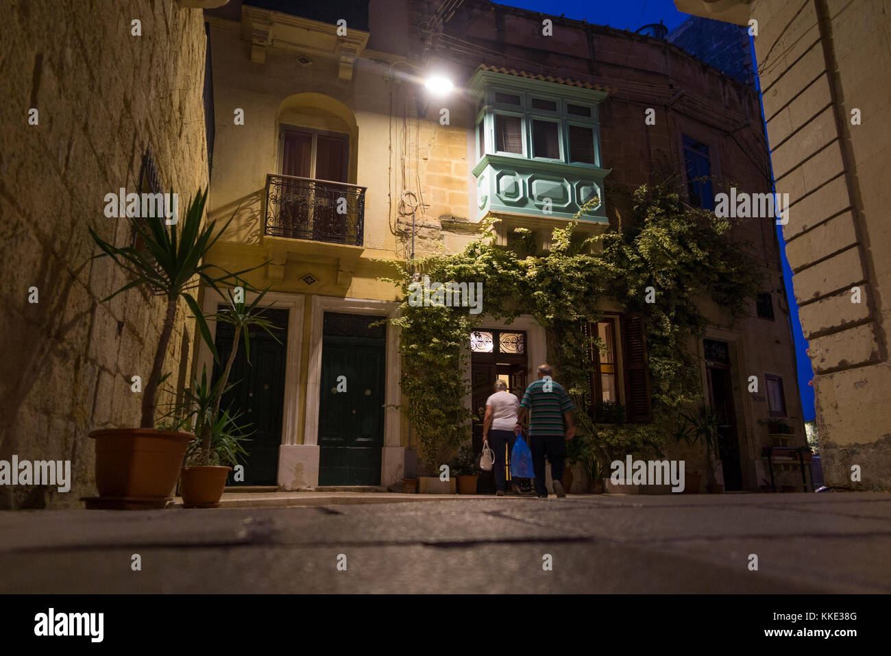 Paar/Menschen kommen in ruhigen Straßen & Straßen von Portomaso, Malta, am frühen Abend/Nacht. Birgu ist auch durch seine Titel Città Vittoriosa bekannt. Stockfoto