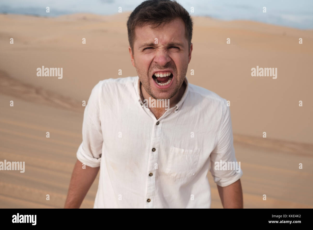 Zornigen Mann schreiend warf jemand in der Wüste Stockfoto