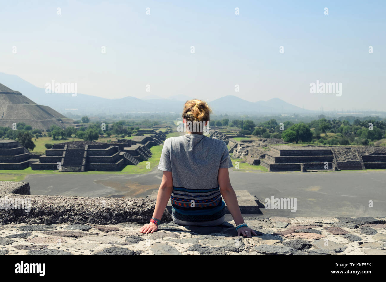 Junge weibliche saß oben auf der Pyramide und mit Blick auf die Ruinen von Teotihuacan Stockfoto