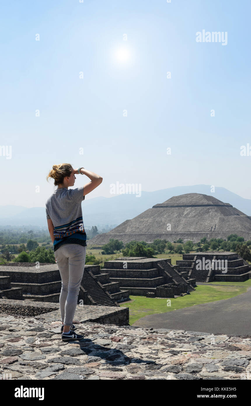 Junge Frau an der Spitze der Pyramide, die ihre Augen von Sun mit Blick auf die Ruinen von Teotihuacan Stockfoto