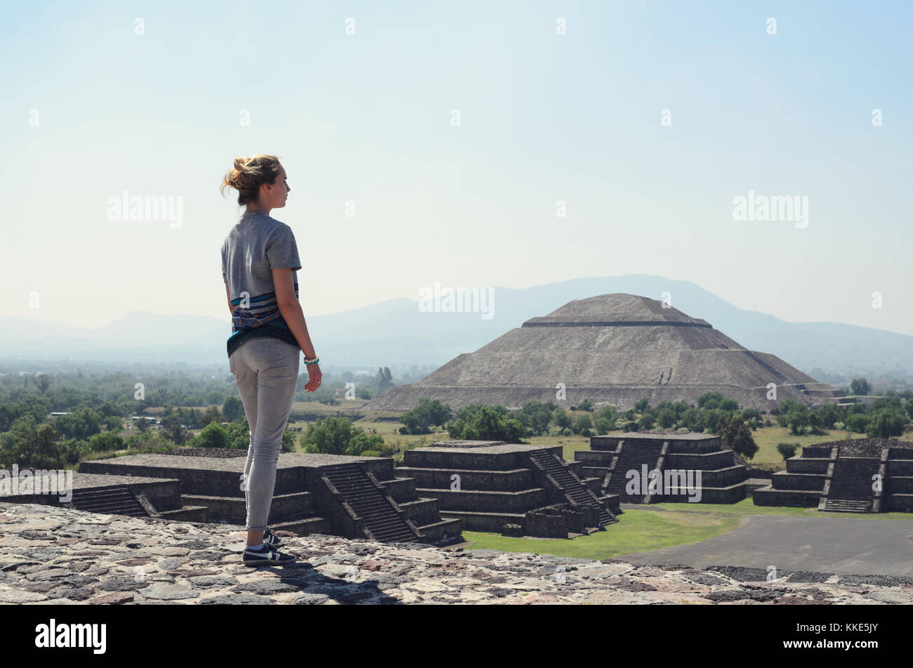 Junge Frau stand an der Spitze der Pyramide und mit Blick auf Machu Picchu Stockfoto