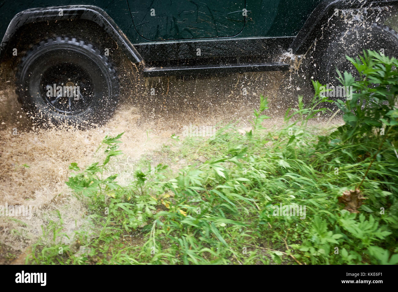 4 wd Wattiefe einen flachen Stream bei Drehzahl verursacht einen Spritzer Wasser aus der Räder in der Nähe zu niedrigen Winkel anzeigen Stockfoto