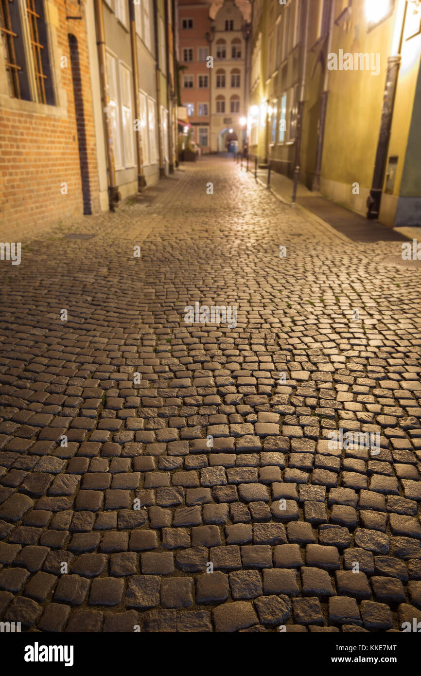 Blick auf Kopfstein Pflaster auf der leeren kramarska Straße an der Stadt (Altstadt) in Danzig, Polen, am Abend. Konzentrieren Sie sich auf den Vordergrund. Stockfoto