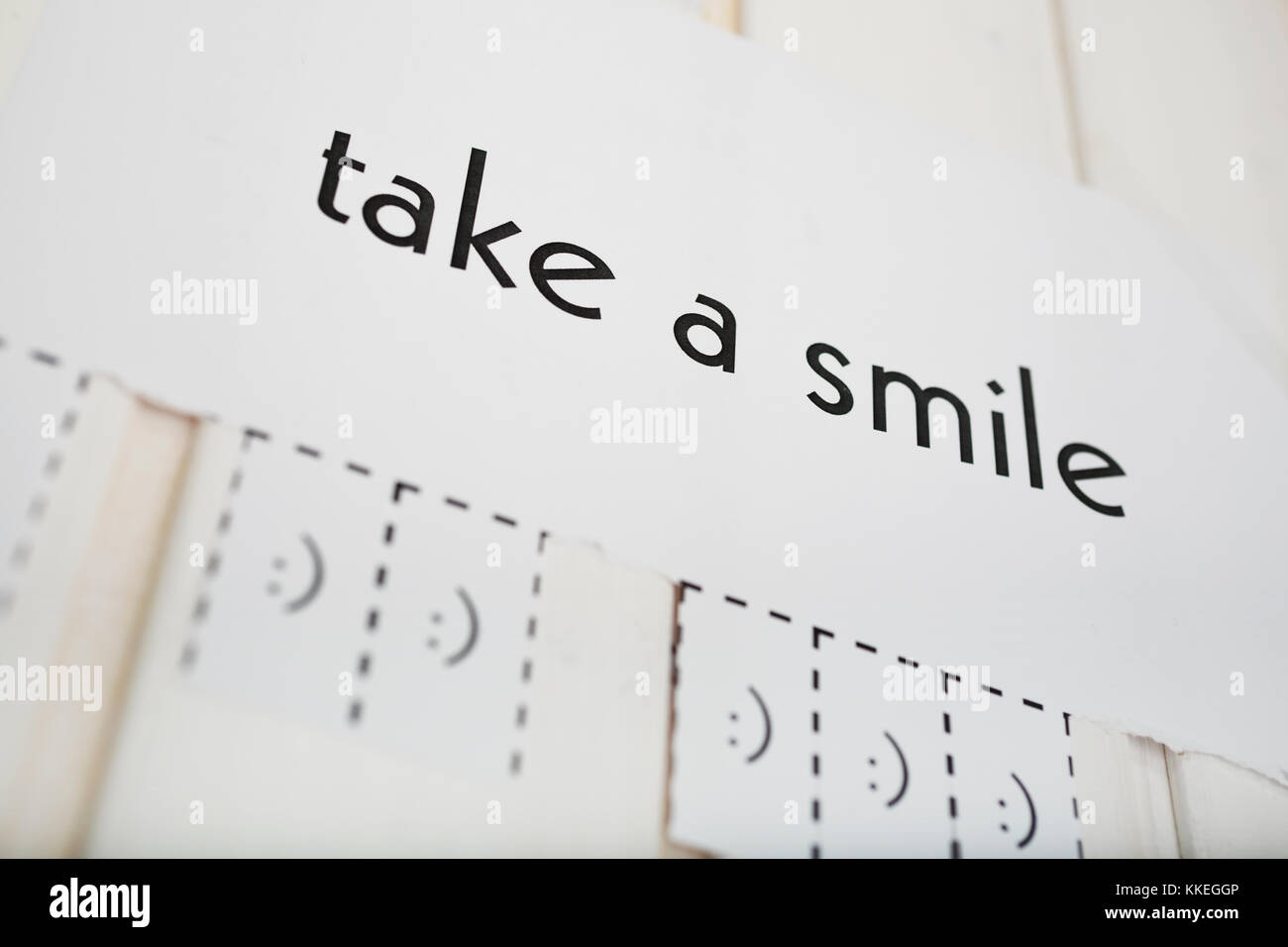 Ein Papier mit den Satz: "Ein Lächeln nehmen und mit einem Lächeln Zeichen bereit zu weg zerrissen werden. Freiheitsgrad. Der Fokus liegt auf der einen Brief. Stockfoto