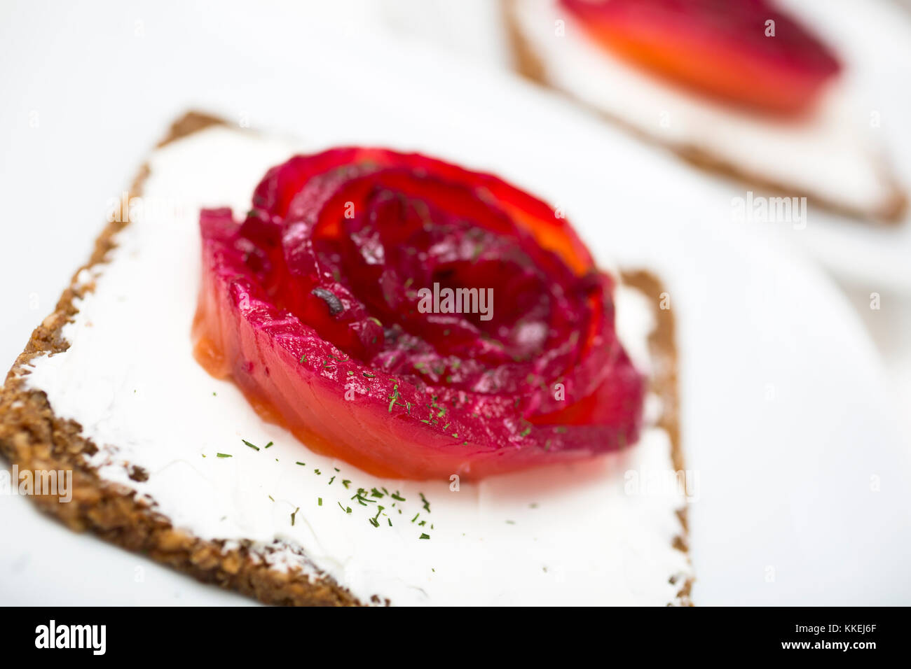 Vorspeise von mariniertem Lachs über ein schwarzes Brot mit Dill gefärbt mit Rote Bete. Stockfoto