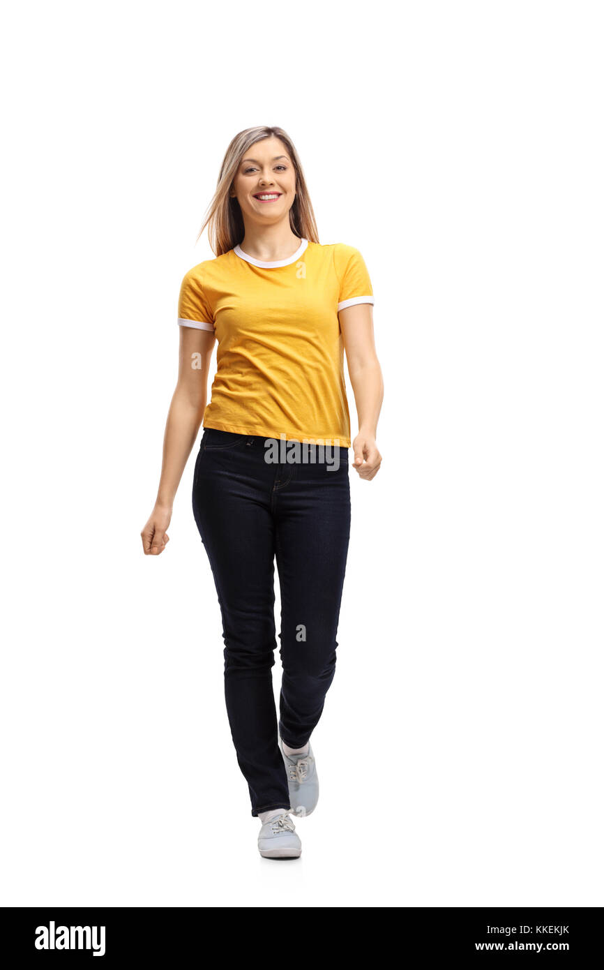 In voller Länge Porträt einer jungen Frau auf dem Weg zur Kamera und lächelnd auf weißem Hintergrund Stockfoto