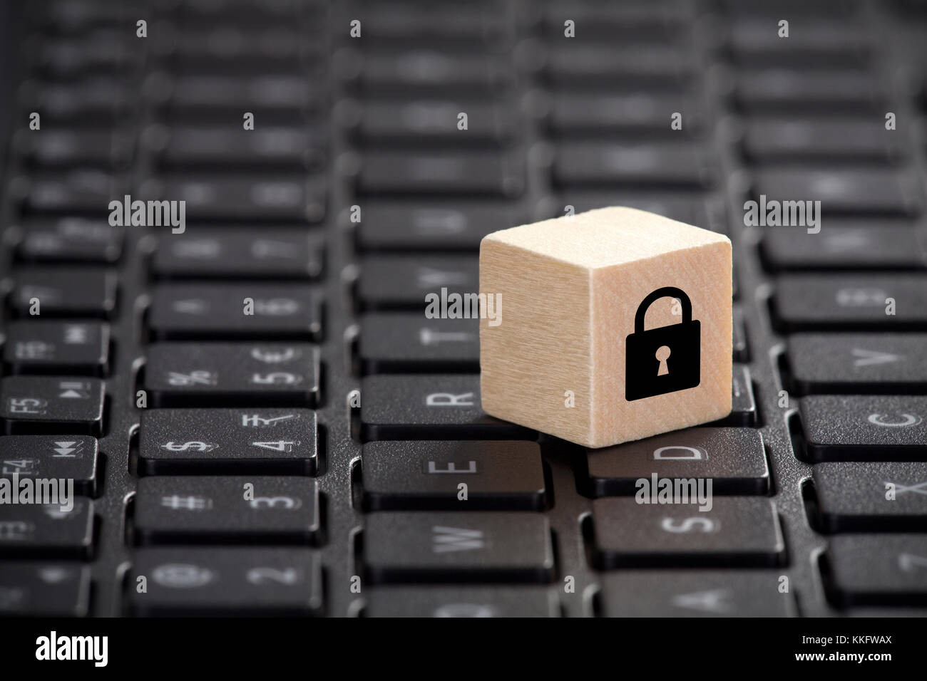 Holzblock mit Schloss Grafik auf Laptop Tastatur. Computer Security Konzept. Stockfoto