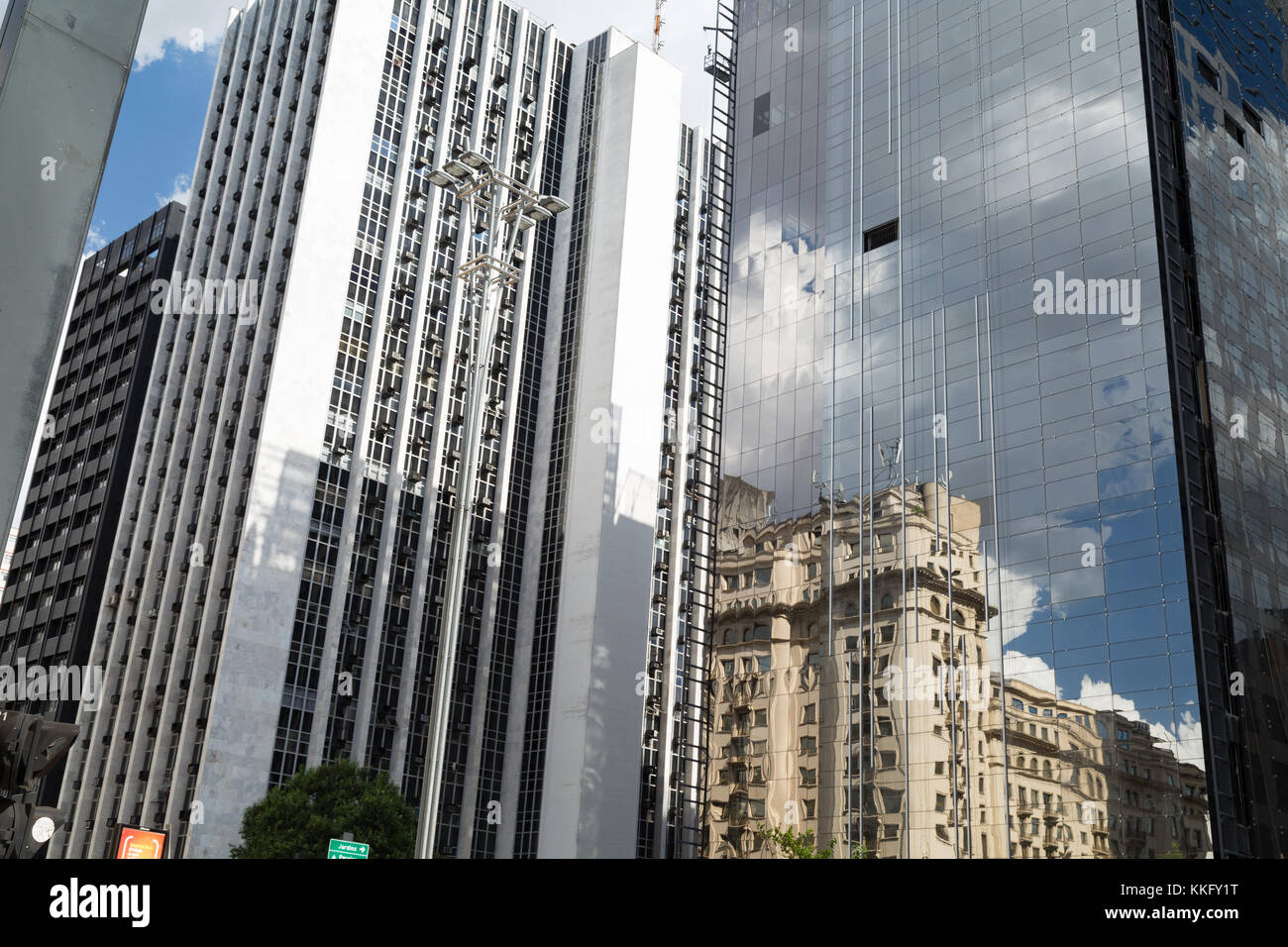 Reflexionen von bewölkt blauer Himmel und alte Gebäude in ein neues Glas Office Business Building, der Avenida Paulista (Paulista Avenue), Sao Paulo, Brasilien Stockfoto