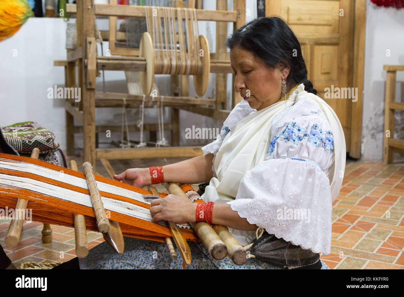 Ecuador Kultur - eine indigene Frau mittleren Alters das Weben mit einem herkömmlichen Back Strap Webstuhl, Otavalo, Ecuador, Südamerika Stockfoto