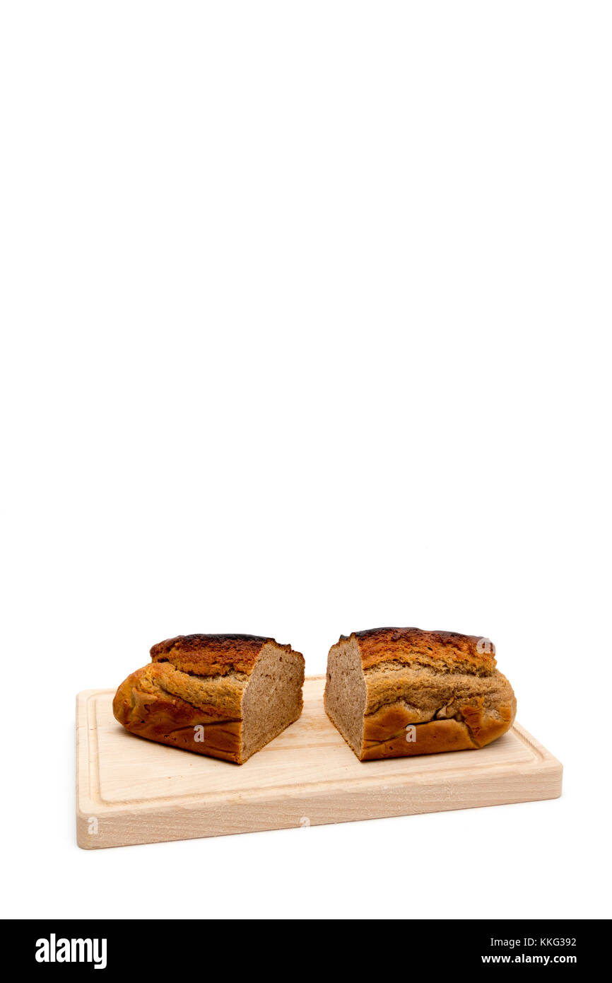 Ein hausgemachtes Plumcake, stehend auf einem Holzbrett mit einem weißen Hintergrund. Stockfoto