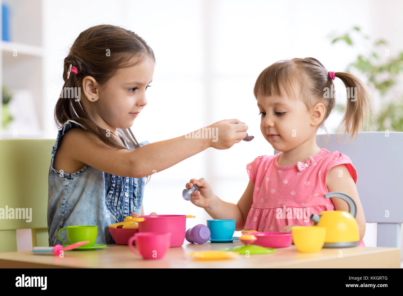 Kinder spielen mit Plastikgeschirr Stockfoto