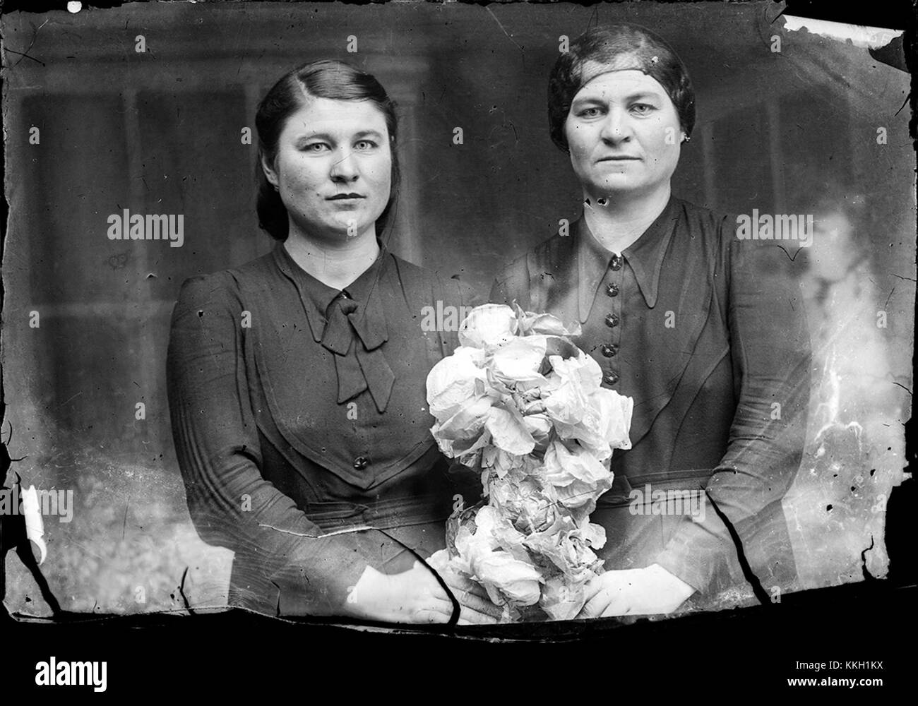Dieses Bild zeigt zwei Frauen mit einem Blumenstrauß, aufgenommen im Dezember 2013. Das Foto unterstreicht die natürliche Schönheit des Blumenarrangements und die Ausdrucksformen der Frauen von Freude oder Gelassenheit. Stockfoto