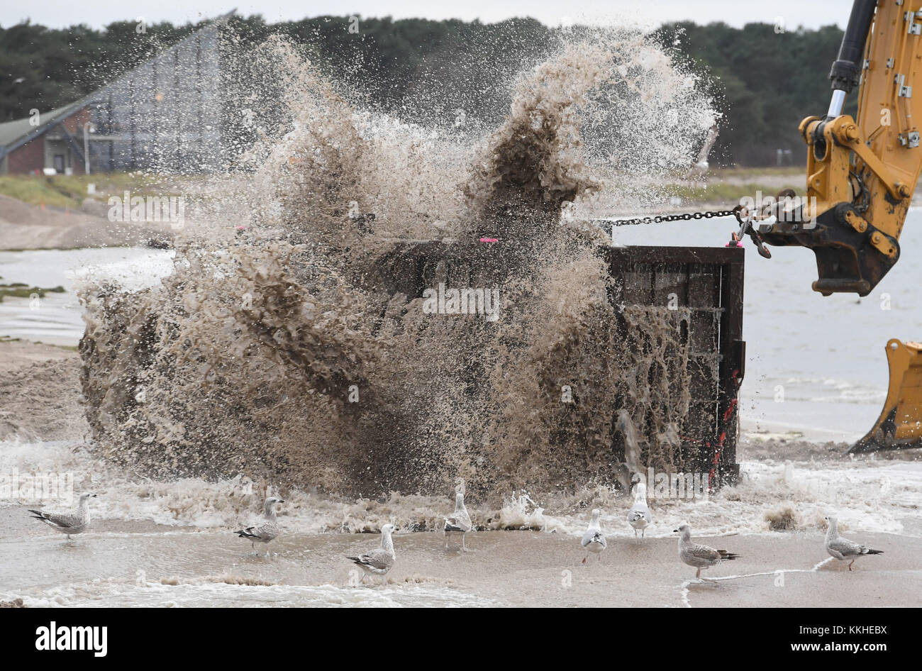 Rügeninsel, Deutschland. Dezember 2017. Ein Bulldozer zieht ein großes Metallsieb durch angespülten Sand, um den Sand von der möglichen Munition aus dem Zweiten Weltkrieg für eine Küstenwasserschutzdüne am Strand von Glowe auf Rügen zu entfernen und zu reinigen, am 1. Dezember 2017. Das Projekt, das mit einem Preis von 3, 5 Millionen Euro durchgeführt wird, zielt darauf ab, den 1.530 Meter langen Strand in Glowe mit rund 130.000 Kubikmetern Sand vor drohenden Sturmfluten zu schützen. Quelle: Stefan sauer/dpa-Zentralbild/dpa/Alamy Live News Stockfoto