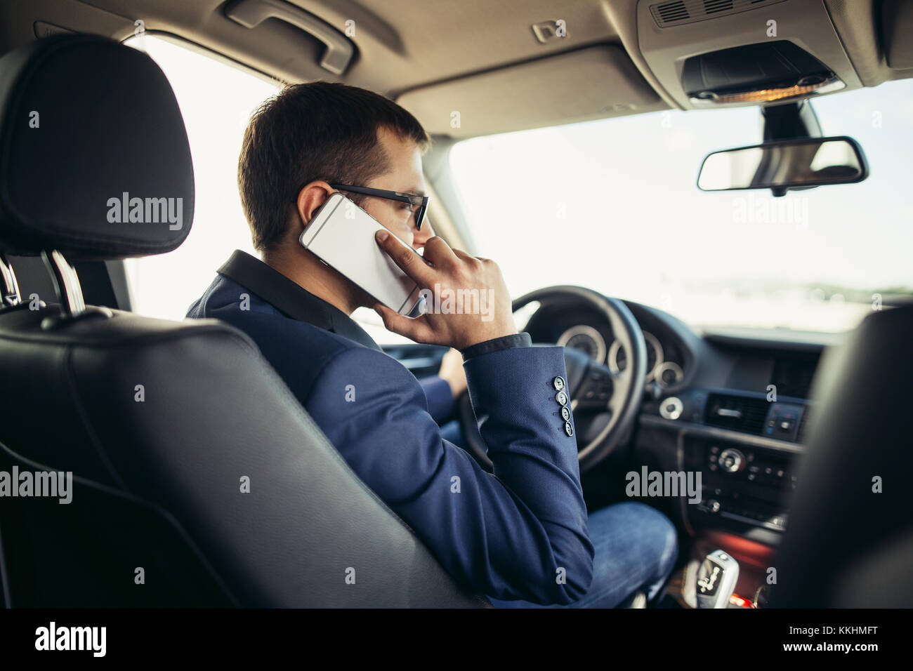 Mann im Auto lesen und Telefonieren Stockfotografie Alamy