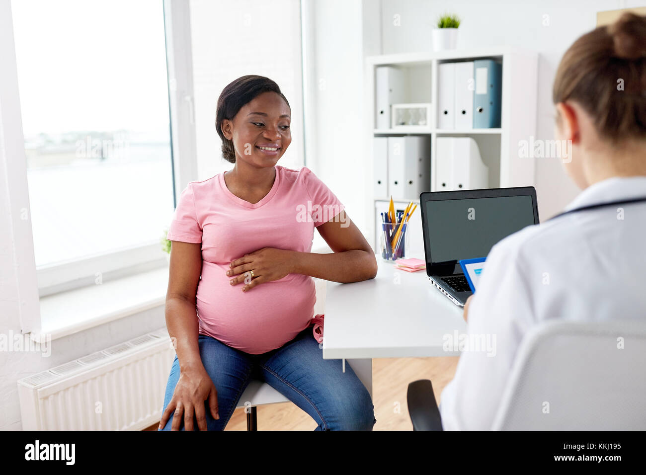 Frauenarzt und glückliche schwangere Frau im Krankenhaus Stockfoto