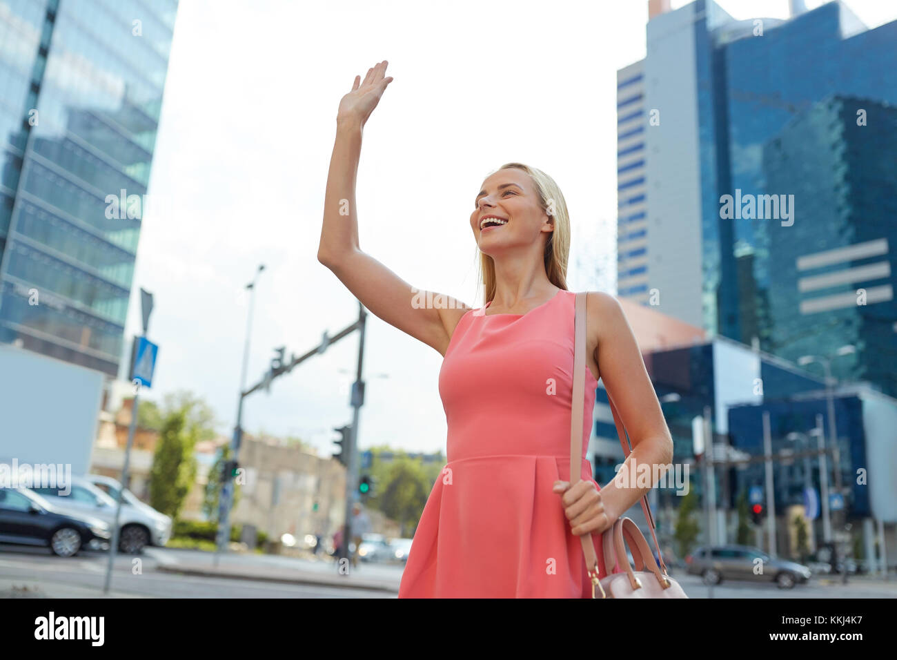 Glückliche junge Frau, die winkende Hand auf Stadt. Stockfoto