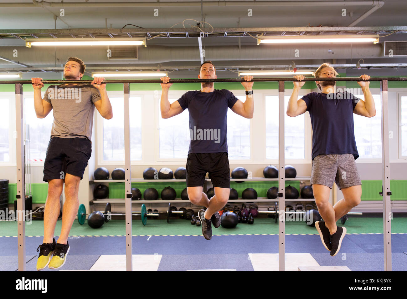 Gruppe junger Männer tun Klimmzüge im Fitness-Studio Stockfoto