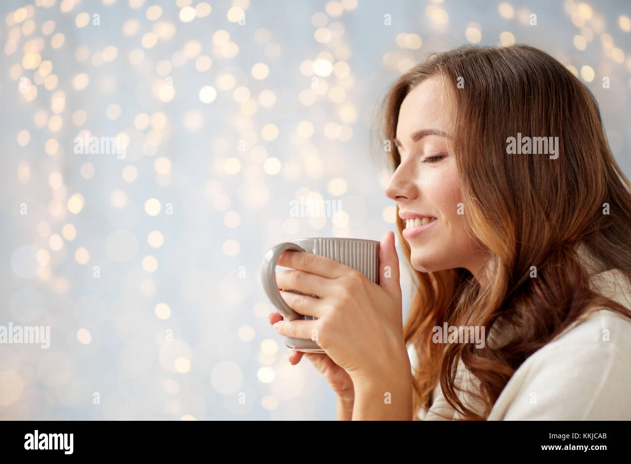 glückliche Frau mit Tasse Tee oder Kaffee zu Hause Stockfoto