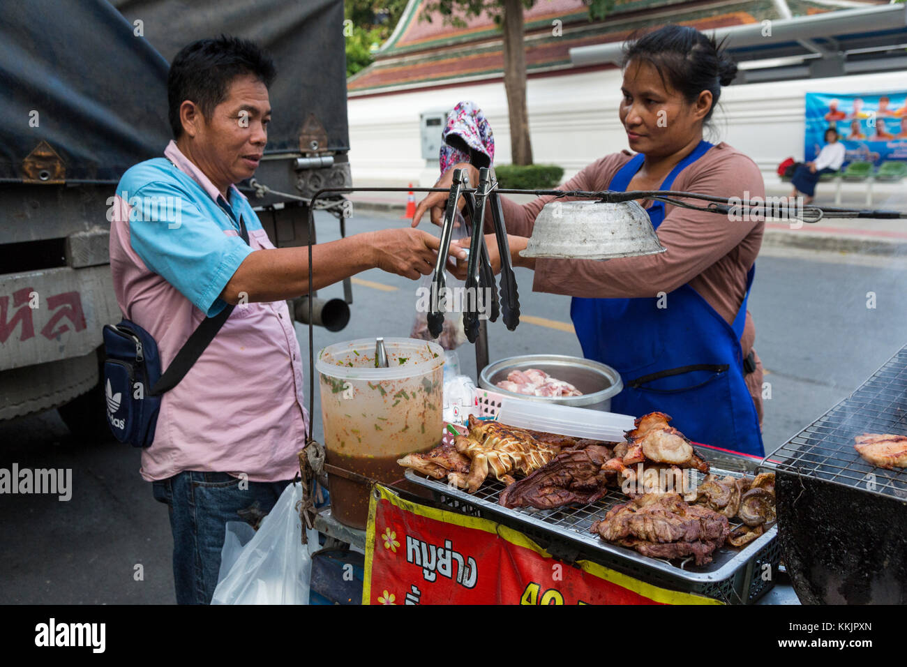 Bangkok, Thailand. Street Food Anbieter an ihrem Stand mit einem Kunden. Stockfoto