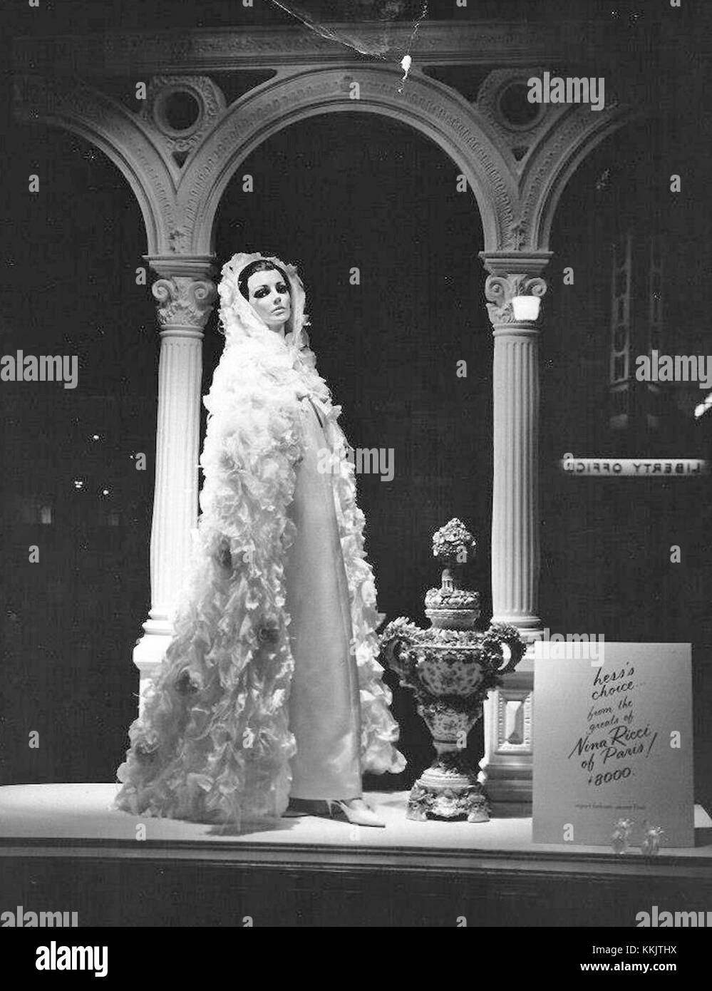 Die Schaufensterpräsentation im Hess Brothers Department Store 1965 zeigte ein elegantes Kleid von Nina Ricci aus Paris, das zu einem Preis von 8.000 US-Dollar kostete und die Luxusmode der damaligen Zeit unterstreicht. Stockfoto